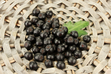 chokeberry with green leaf on wicker mat close-up