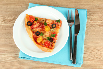 plate with a slice of delicious pizza on wooden background