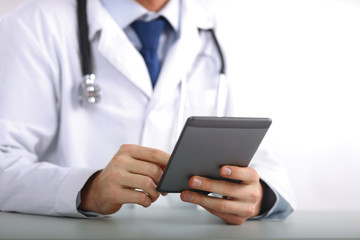 Handsome doctor using computer plane-table