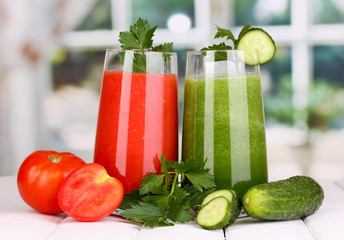 Fresh vegetable juices on wooden table, on window background