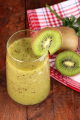 Glass of fresh kiwi juice on wooden table