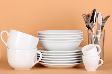Fototapeta na wymiar Clean white dishes on beige background
