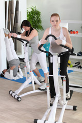 Women using stepper machine in gym