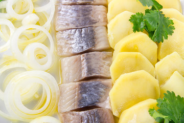 Portion of herring fish fillets with potato and onion