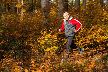 Senior joggt im Herbstwald