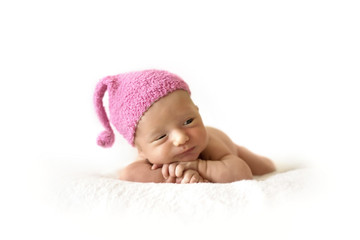 cute newborn baby in a pink berry cap on white background