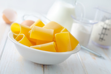 Raw yellow pasta and ingredients for pasta, sugar and flour
