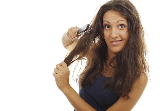  Hübsche Frau bürstet ihre Haare mit einer Grimasse aus