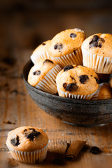 Fresh mini muffins on aged wood background