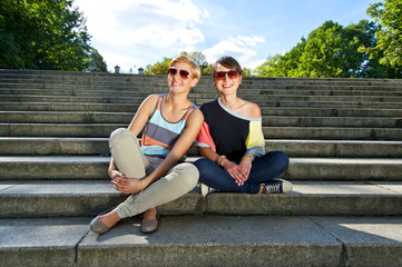 Two  beautiful woman with sunglasses on the stairs