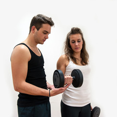 Woman exercising with her personal trainer at the Gym.