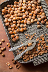 Hazelnuts with nutcracker and nutshel in old basket