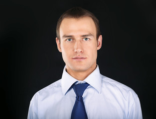 A portrait of a man standing isolated on black background