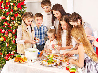 Children rolling dough in kitchen.