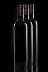 3 Bottles of red wine on black background