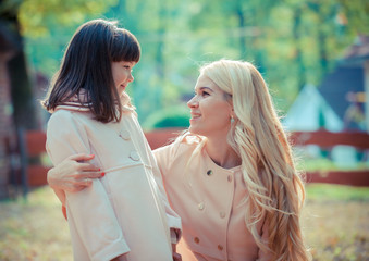 happy young mother with the daughter in park