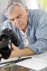 Photographer in office looking at camera screen