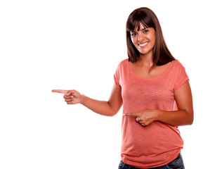 Stylish young woman looking at you pointing right