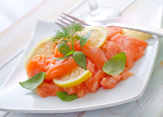 fresh salmon with lemon on the white plate