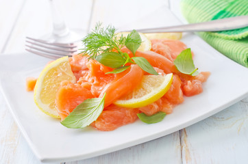 fresh salmon with lemon on the white plate