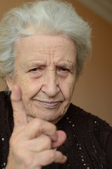 old woman with her finger up for admonition