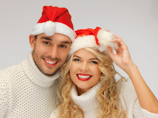 family couple in sweaters and santa's hats