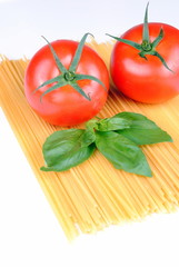 raw spaghetti, tomatoes and basil on white,  soft shadows