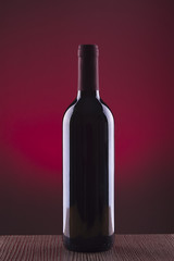 Botella de vino sobre fondo rojo