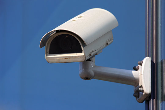 white cctv security camera on blue background