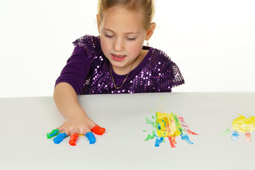 Kind malt mit Fingerfarben