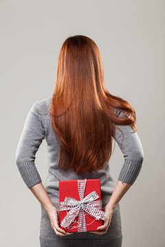 Woman hiding a gift behind her back