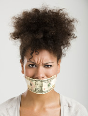 Covering mouth with a dollar banknote