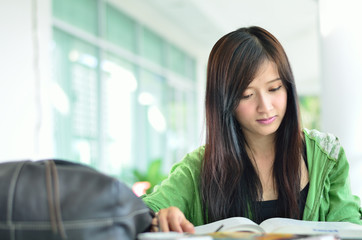beautiful asian girl is reading in college