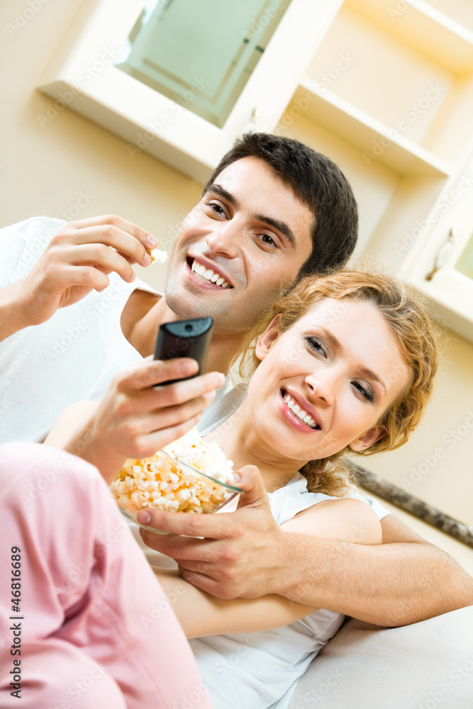 Wall mural cheerful young couple watching tv together