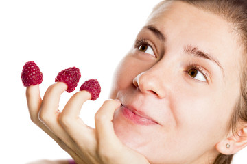Cute girl eating raspberries from fingers. © lichtmeister