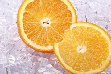Foto op Plexiglas gesneden sinaasappel op een stuk ijs © Andrew