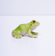 side view of plastic frog, white background