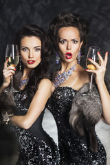 Fashion women drinking champagne in nightclub. Merry Christmas!