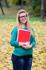 Obraz premium Portrait of smiling student girl holding books