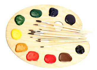 wooden art palette with  paint and brushes.isolated on white