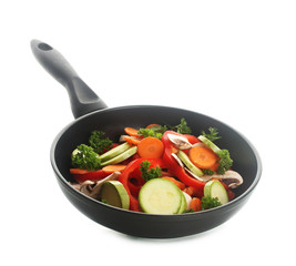 frying pan with vegetables on white