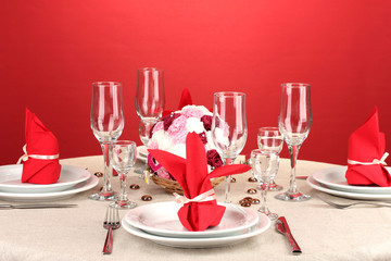 Table setting in red tones on color  background