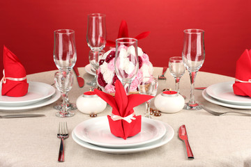 Table setting in red tones on color  background