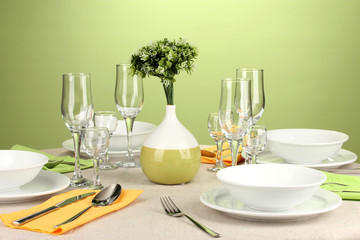 Table setting in green and yellow tones on color  background
