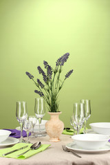 Table setting in violet and green tones on color  background