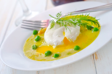 Fresh soup from green peas and egg-poached