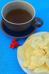 Cornflakes with hot tea, blue table, red flower