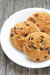 Homemade  chocolate chip cookie on a white plate.
