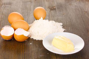 Eggs, flour and butter close-up on wooden table