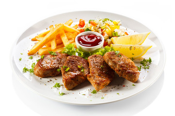 Grilled steaks, French fries and vegetables